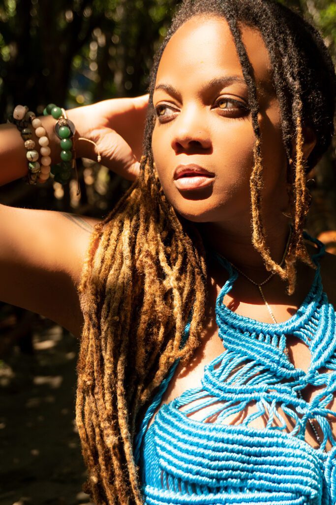 Close up of a black beautiful girl with green eyes and dreadlocks posing in a tulum's cenote