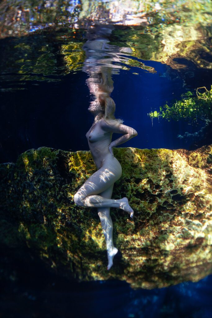 artistic nude of a woman posing underwater in the magical cenotes