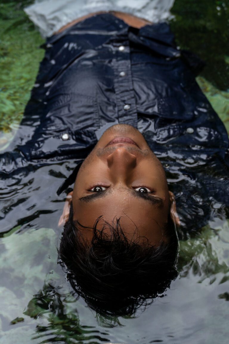 closeup of a boy lying in the water of a cenote