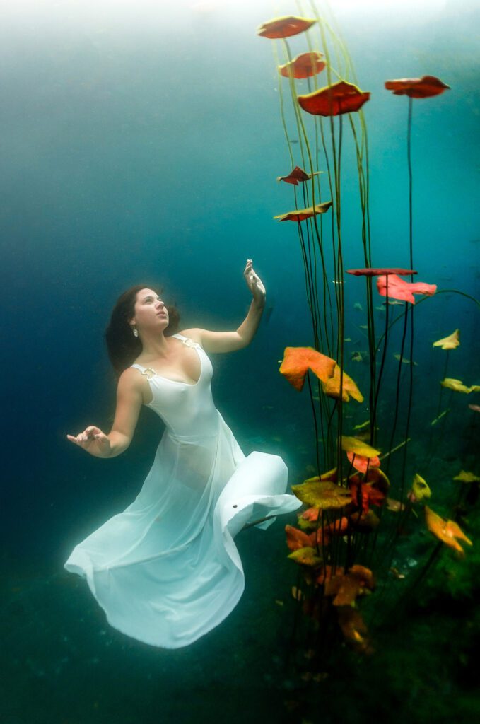 "underwater girl next to beautiful lilies in cenote"