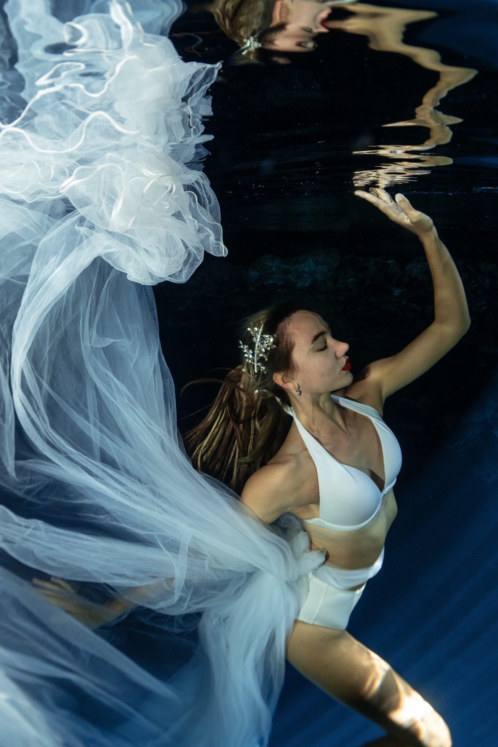 "underwater girl portrait in cenote with a white flowing dress"